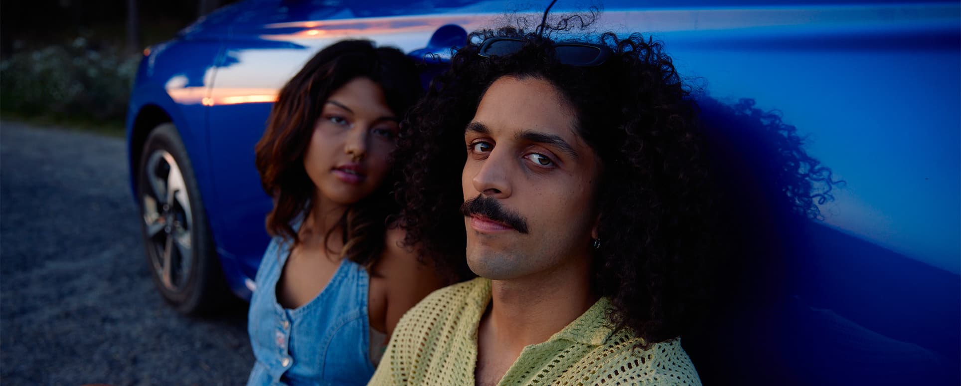 Mann und Frau sitzen mit dem Rücken angelehnt an einem Swift