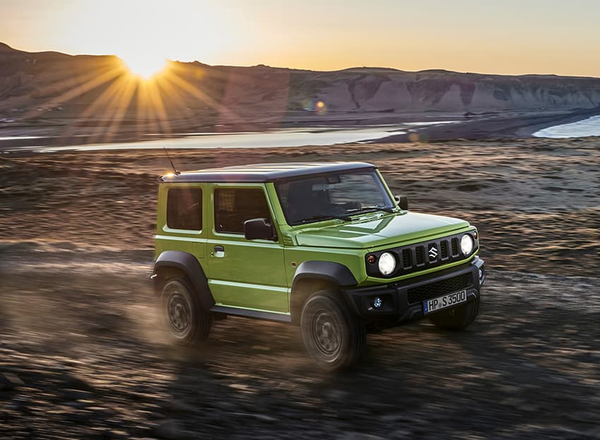 Ein Jimny fährt über ein Offraod-Gelände bei Sonnenuntergang